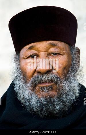 Porträt eines äthiopisch-orthodoxen Priesters, der am Damaskus-Tor in der Altstadt von Jerusalem sitzt. Stockfoto