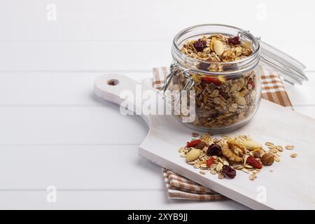 Schüssel hausgemachtes Müsli mit Nüssen, Beeren, getrockneten Früchten, Glas Milch und Honig. Gesundes Frühstück. Draufsicht Stockfoto