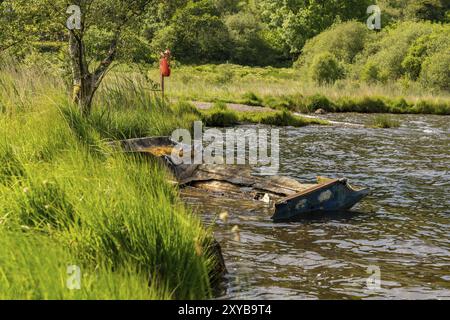 Ein beschädigtes Boot am Ufer des Llyn Geirionydd, in der Nähe von Llanwrst, Conwy, Wales, Großbritannien Stockfoto