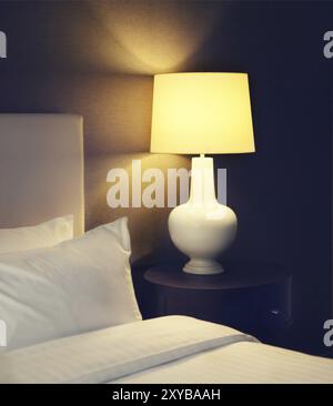 Abstrakte Hotel Schlafzimmer mit Lampe und Hotel Bett mit Platz für Text. Getönten Bild Stockfoto