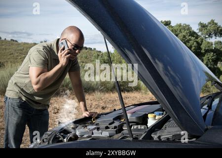 Nahaufnahme eines aufgeschlüsselt Auto, Motor öffnen und Rauchen, in einer ländlichen Gegend und der Blick auf den Motor-Treiber Stockfoto