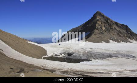 Reiseziel in den Schweizer Alpen. Glacier de Diablerets im Sommer. Gipfel des Oldenhorns. Großes Loch im Gletscher, wo ein temporärer See verschwindet Stockfoto