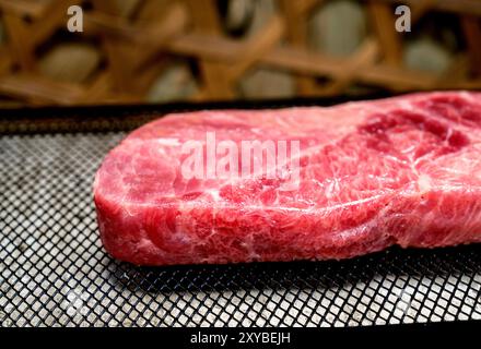 Ein Stück Lendenfleisch wird in Scheiben geschnitten und auf ein Backblech gelegt. Das Fleisch ist rosa und hat eine Menge Textur Stockfoto