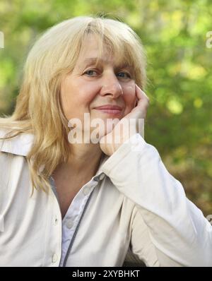 Mittlere gealterte Frau Blick in die Kamera mit glücklichen Lächeln Stockfoto