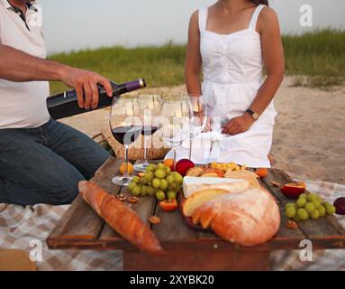 Menschen bei Wein Party im Freien. Weinfest. Man gießt Rotwein in der weingläser. Nahaufnahme Stockfoto