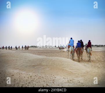 Gruppe von Touristen, die eine Wüstenkamel-Safari machen. Sahara-Landschaft, Tunesien, Afrika Stockfoto