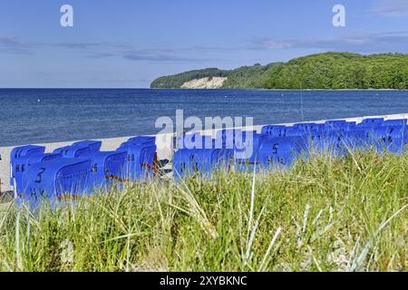 Blick auf einen Strand mit blauen Liegestühlen und weißen Kreidefelsen im Hintergrund, Rügen (Binz 1) Stockfoto