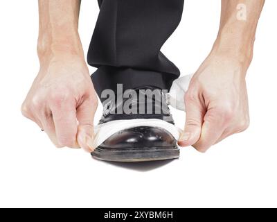 Nahaufnahme der männlichen schwarz glänzenden Leder Schuhe mit ein Blatt weißes Gewebe auf weißem Hintergrund Stockfoto