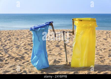 Leere Müllsäcke am portugiesischen Sandstrand mit blauem Meer Stockfoto