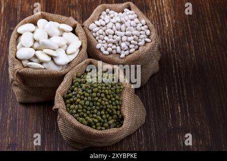 Bohnen Sorte, verschiedene Arten von Bohnen in Sackleinen auf hölzernen Hintergrund entlassen Stockfoto