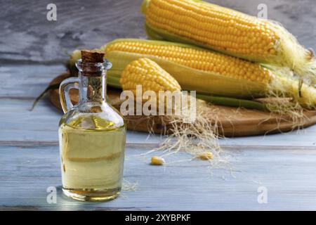 Frischer Mais mit Flasche Öl auf Holz Hintergrund Stockfoto