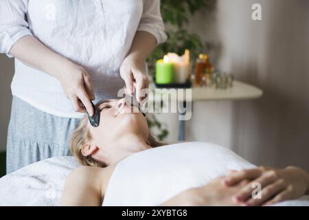 Junge Frau haben Gesicht Guasha Behandlung im Asian Beauty Klinik Stockfoto