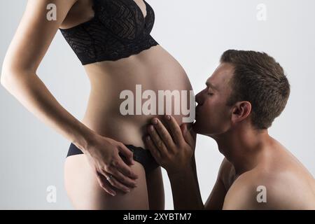 Junge Menschen und schwangere Frau Küssen in Studio Stockfoto