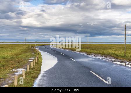 In der Nähe von Beal, Northumberland, England, Großbritannien, 08. September 2018: überflutete Straße zur Heiligen Insel Lindisfarne mit einem Wagen Stockfoto