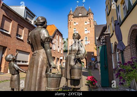 Bronzeplastik 'Frauen an der Wasserpumpe' und das innere Klever Tor in Xanten, Niederrhein, Nordrhein-Westfalen, Deutschland, Europa | Skulptur 'W Stockfoto