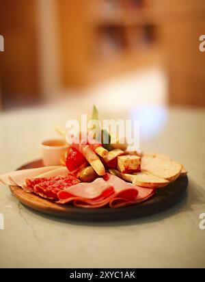 Mischung aus traditionellen spanischen Schinken Salami, Parma Schinken auf grissini Brot Sticks, mariniertes Gemüse und Oliven auf Holzplatte mit rustikaler Einrichtung. Nacht pa Stockfoto