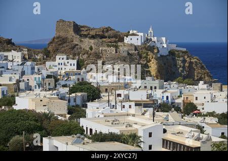 Weiß getünchte Gebäude und eine historische Burg erstrecken sich über einen felsigen Hügel mit Blick auf das tiefblaue Meer, das Morgenlicht, Panagia Spiliani, Schloss, Mandra Stockfoto