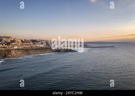 Ericeira Drohne aus der Vogelperspektive an der Küste Portugals mit Surfern auf dem Meer bei Sonnenuntergang Stockfoto