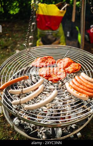 Fleischprodukte, die auf einem beheizten Grillrost über heißer Holzkohle gegrillt werden Stockfoto