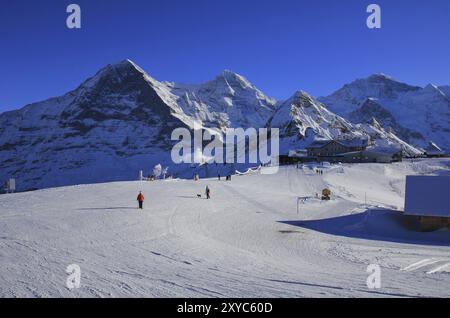 Winterszene in Grindelwald, Schweizer Alpen. Skipiste und schneebedeckte Berge Eiger, Mönch, Lauberhorn und Jungfrau Stockfoto