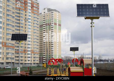Ein Kinderspielplatz im Hof eines Mehrfamilienhauses mit Sonnenkollektoren Stockfoto