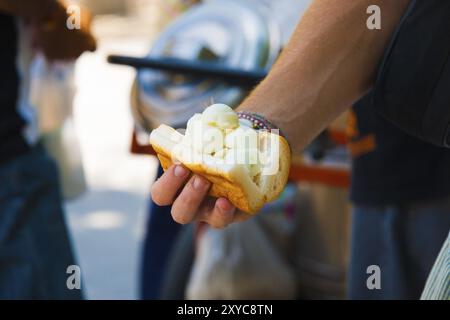 Eine ungewöhnliche thailändische Version eines Eis-Sandwiches, ein Eis mit Kokosgeschmack in einem weißen Brotbrötchen, ist ein Street Food, das in Thailand als Snack verkauft wird Stockfoto