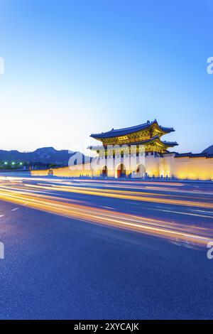 Farbenfrohe Streifenlichter passieren vor dem beleuchteten Tor von Gwanghuamun, Eintritt zum historischen Gyeongbokgung Palast in der Dämmerung in der Innenstadt von Seoul Stockfoto