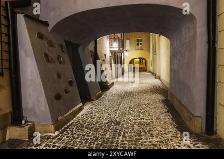 Schmale verschneite Straße mit Kopfsteinpflaster im winter nacht in der Altstadt von Warschau in Polen Stockfoto