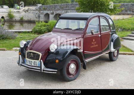 Retro Citroen 2CV Oldtimer in Rot und Schwarz, geparkt auf einer Straße vor einer Steinbrücke in grüner Umgebung, Citroen, Chambord Castle, Chateau de C. Stockfoto