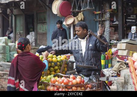 Bhaktapur, Nepal, 5. Dezember 2014: Obstverkäufer mit einem Kunden in den Straßen, Asien Stockfoto