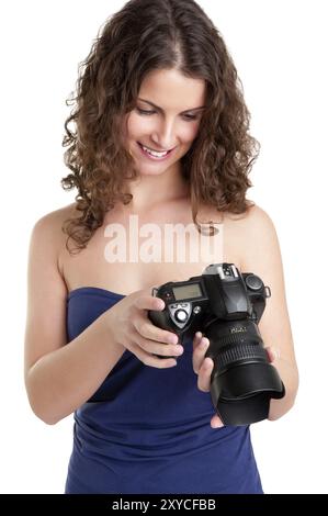 Frau hält eine SLR-Kamera und Blick auf das Bild, nahm sie, isoliert in weiß Stockfoto