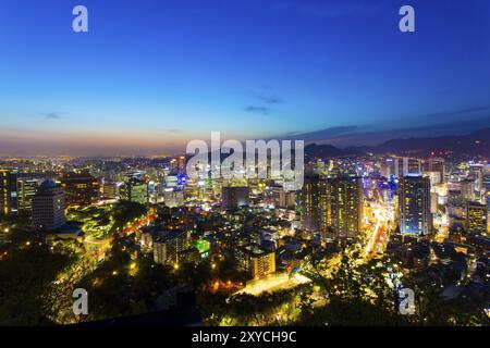 Farbenfroher Sonnenuntergang hinter einem hohen Blick auf die Innenstadt von Seoul mit Geschäftsgebäuden und Bergen am Horizont in der Abenddämmerung an einem klaren Himmel Frühling ni Stockfoto