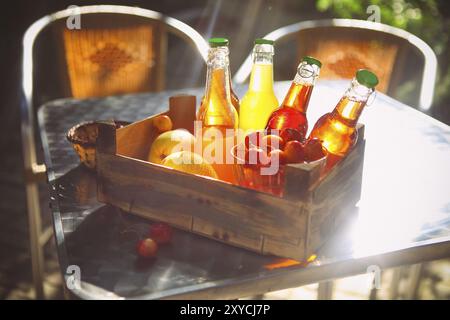 Limonade mit Kirsche, Birne und Zitrone in der Holzkiste auf dem Garten Picknick Stockfoto