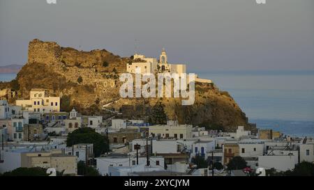 Weiß getünchte Häuser und eine alte Burg auf einem Hügel in der Dämmerung mit Blick auf das ruhige Meer, Morgenlicht, Panagia Spiliani, Schloss, Mandraki, Nisyros, Dodec Stockfoto