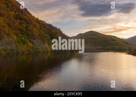 see in den Bergen an einem sonnigen Abend. Wald reflektiert sich im Wasser. Wunderschöne Landschaft rumäniens in der Herbstsaison. oktober Sonnenuntergang Wetter Stockfoto