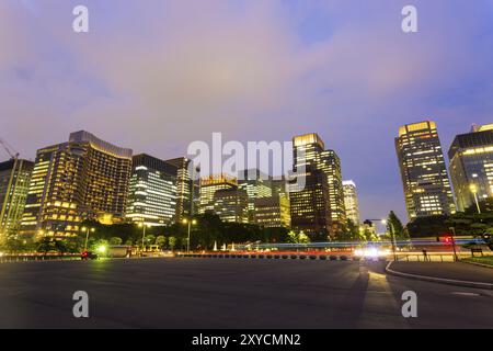Skyline des Stadtteils Marunouchi und nächtlicher Verkehr, Wolkenkratzerfenster unter dem Dämmerhimmel in Tokio, Japan und Asien Stockfoto
