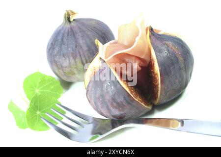Feigen mit Serrano-Schinken und Kapuzinerkresse auf weißem Hintergrund Stockfoto