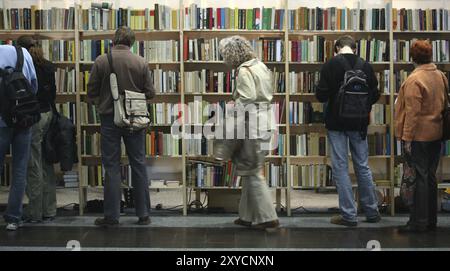 Leute vor vollen Bücherregalen Stockfoto