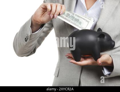 Geschäftsfrau, die die Sparkasse und die Dollarscheine in den Händen hält Stockfoto