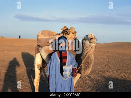 Marokko. Marrakesch. Ein einheimischer Mann mit seinem Kamel in der Wüste. Stockfoto