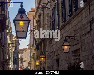 Straße bei Nacht mit beleuchteten Laternen und verschiedenen Ladenschildern vor alten Gebäuden, dubrovnik, Mittelmeer, Kroatien, Europa Stockfoto