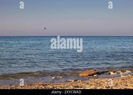 Blaue Farbe des Mittelmeers am späten Nachmittag. Am Horizont hellrosa Farbe des Himmels, Beginn des Sonnenuntergangs. Djerba, Tunesien. Stockfoto