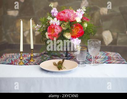 Tischdekoration im Vintage-Stil ist mit Blumen in rosa und blauen Farben dekoriert. Stockfoto