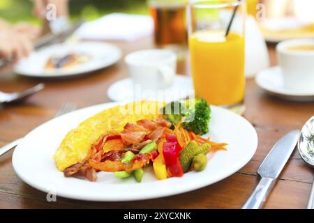 Omelett mit Paprika, Gurken, Bakon und Salat auf den Tisch im Freien Stockfoto