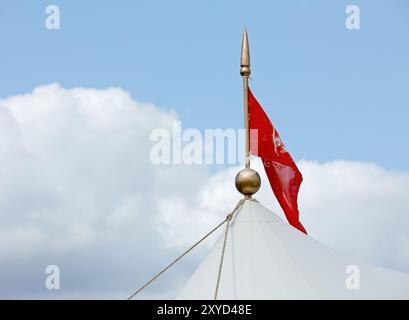 Ein kleiner roter Wimpel vor hellblauem Himmel Stockfoto