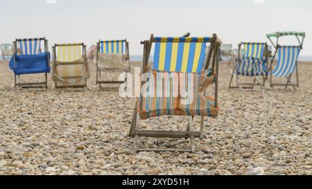 Leere Liegestühle auf einem Kieselstrand Stockfoto