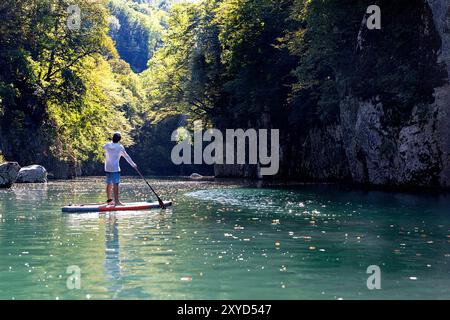 Touristen, Kind auf einer SUP-Reise, Stand-up-Paddelboarder erkunden, paddeln Sie die Schlucht von Soca und Idrijca in der Nähe von Most na Soci, Slowenien Stockfoto