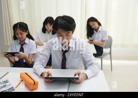 Gruppe von Schülern, die Tablets im Unterricht studieren und verwenden Stockfoto
