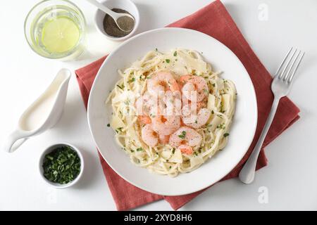 Köstliche Pasta mit Garnelen und Käse serviert auf weißem Tisch, Blick von oben Stockfoto