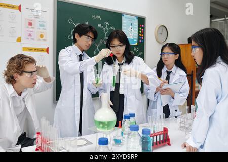 Studenten, die sich mit Chemieexperimenten im Labor beschäftigen Stockfoto